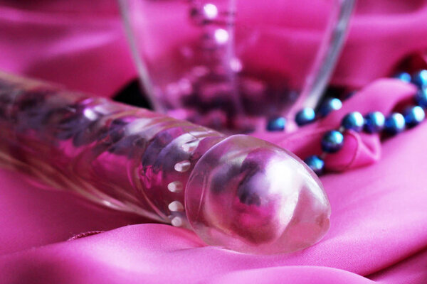 Female pink vibrator and beads. Sex toy for adults.