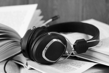 Ses kitabı konsepti. Kulaklıklar ve eski kitaplar ahşap masanın üzerinde..