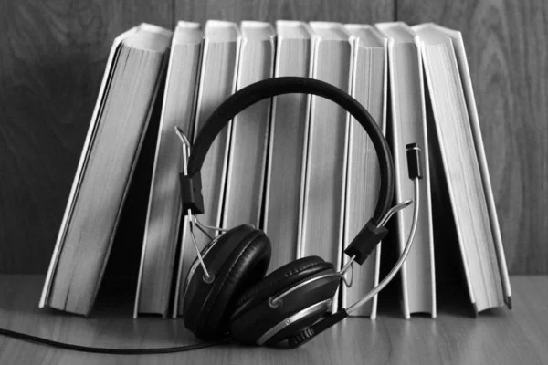 Ηχητική ιδέα βιβλίου. Ακουστικά και παλιό βιβλίο πάνω από ξύλινο τραπέζι. — Φωτογραφία Αρχείου