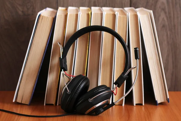 Audioboek concept. Koptelefoon en oud boek over houten tafel. — Stockfoto
