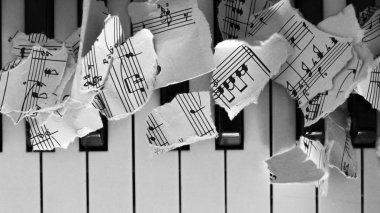 Yırtık müzik notaları, piyano üzerine kağıt parçaları