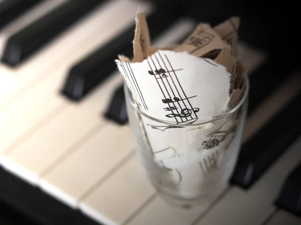 撕破的音符，钢琴上的纸片 — 图库照片