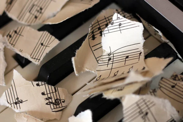 Notas musicales desgarradas, trozos de papel sobre piano —  Fotos de Stock