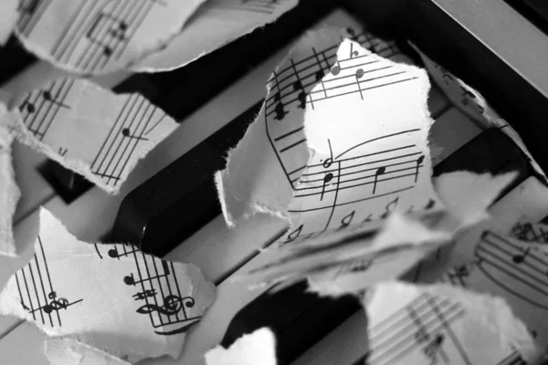 Notas musicales desgarradas, trozos de papel sobre piano — Foto de Stock