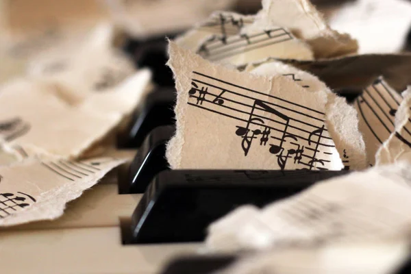 Notas musicais rasgadas, pedaços de papel no piano — Fotografia de Stock