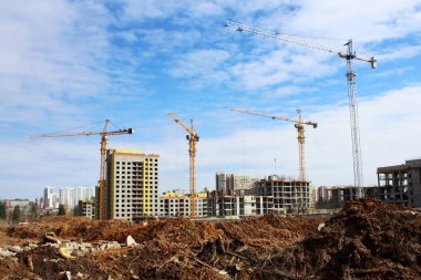 Mavi gökyüzüne karşı şantiye kule vinçler