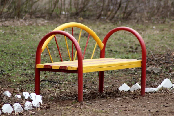 Parlak sarı-kırmızı Park bankı — Stok fotoğraf