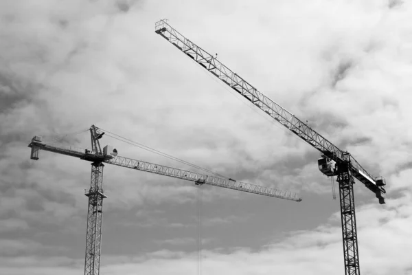 Construcción de grúas torre contra el cielo, blanco y negro — Foto de Stock