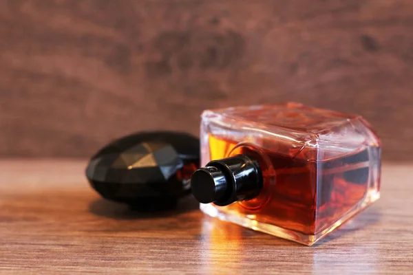 Aromatyczne butelki perfum na drewnianym biurku na drewnianym tle. — Zdjęcie stockowe