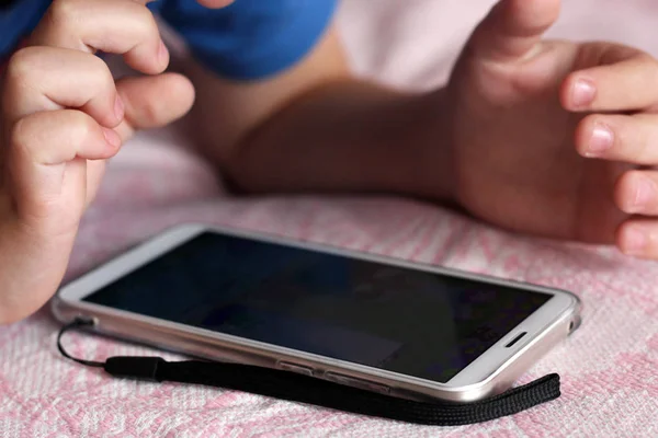 Fechar em cima de um menino com um telefone celular — Fotografia de Stock