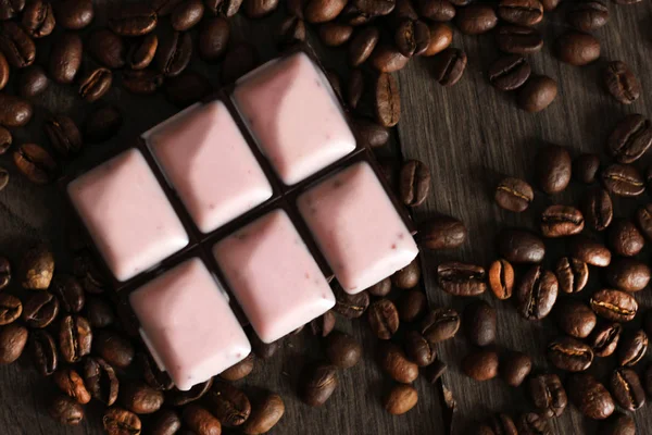 Trozos de chokolate oscuro y granos de café, comida rosa — Foto de Stock