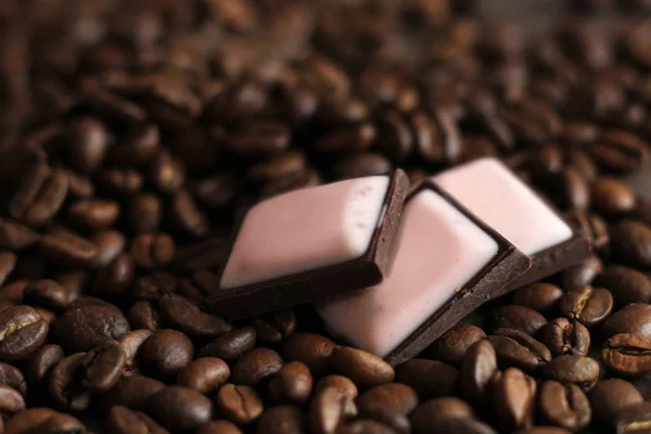 Trozos de chokolate oscuro y granos de café, comida rosa . — Foto de Stock