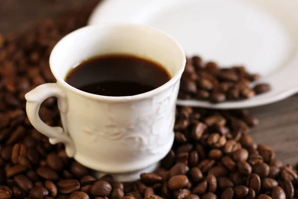 Black coffee in white cup and coffee beans — Stock Photo, Image