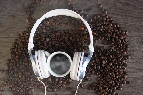 Rosted coffee beans and headphone on a table — Stock Photo, Image