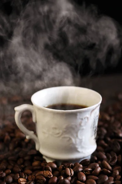 Чорна кава в білій чашці та кавових зернах — стокове фото