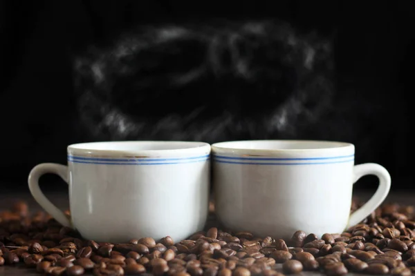 Чорна кава в білій чашці та кавових зернах — стокове фото