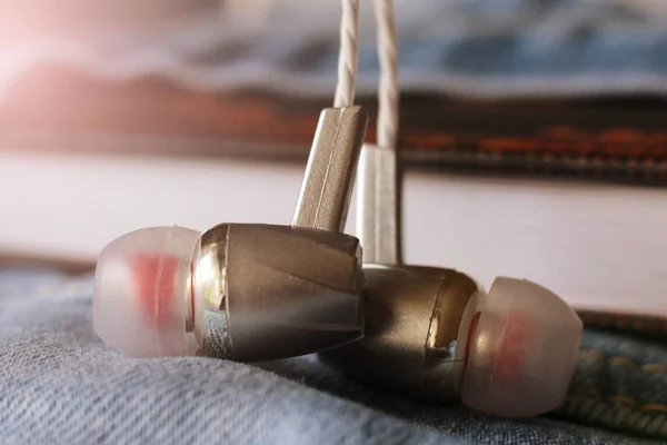 Auriculares plateados en jeans tan cerca —  Fotos de Stock