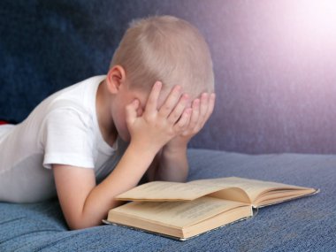 küçük kız yatakta yatıyordu ve kitap okuma
