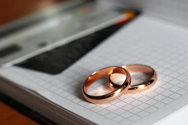 Dos anillos de boda descansando en una página de papel — Foto de Stock