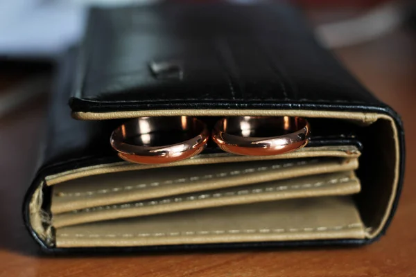 Два обручальных кольца и кожаная сумка — стоковое фото