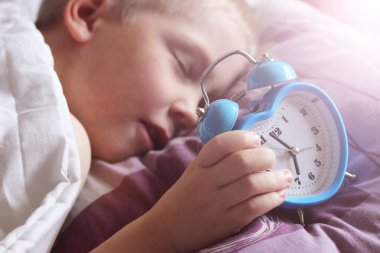 tatlı bir çocuk ile çalar saat başı yakınındaki uyku