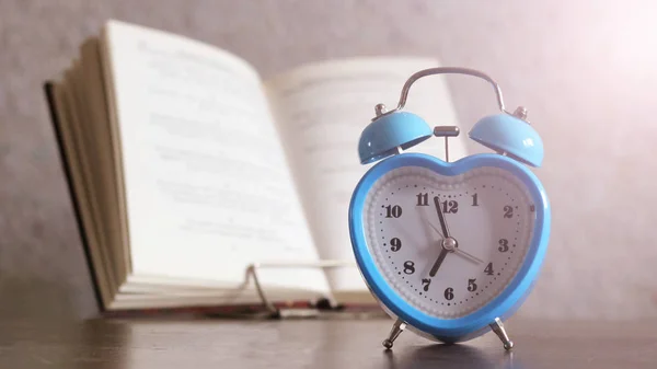 Reloj despertador azul y libro . —  Fotos de Stock