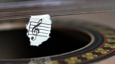 Gitar telleri, yırtık kağıt notalar, müzik.