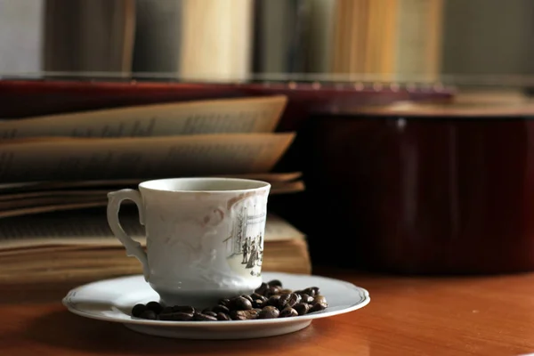 コーヒー カップと木製のテーブルの上のギター — ストック写真