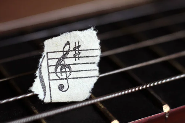 Cordes de guitare et notes de papier déchiré, musique — Photo
