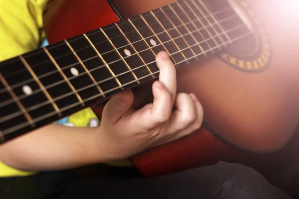Dětská ruka a kytarové struny, naučit se hrát — Stock fotografie