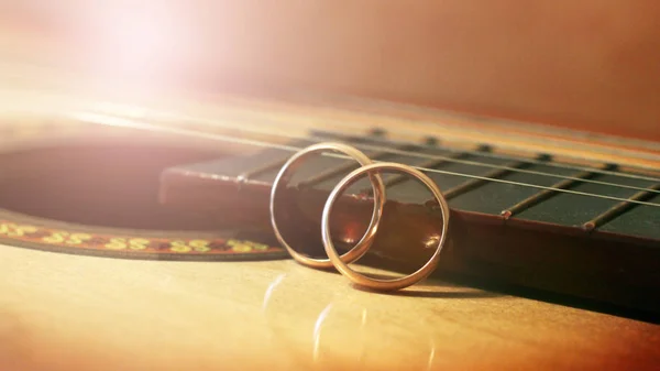 Anéis de casamento nas cordas da guitarra — Fotografia de Stock