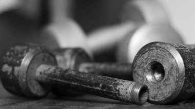 Eski demir, katlanabilir halterler ahşap zeminde, siyah ve beyaz