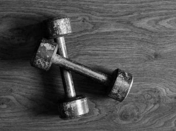 Old iron collapsible dumbbells on the wooden floor — Stock Photo, Image