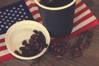 Tahta arka planda Usa bayrağı olan sıcak bir içecek.