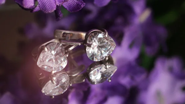 婚約者と紫色の花がとても近い銀のイヤリング — ストック写真