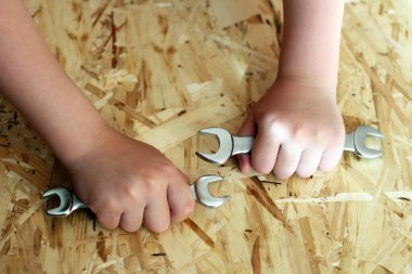 Ahşap arka planda bir anahtarı tutan el.