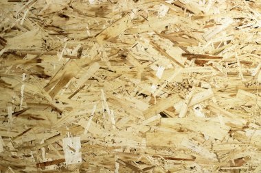 Oryantasyon Strand Kurulu. Çizgili bina malzemesi. OSB ahşap paneli, arka plan yakın çekim olarak kumlu kahverengi ahşap talaşlarından yapılmıştır.