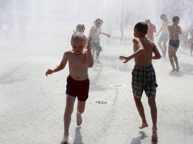 15 Temmuz 2020. İzhevsk, Rusya. Mutlu çocuklar yazın çeşmelerde oynuyorlar.