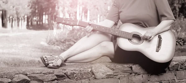 Beautiful girl and retro guitar in the garden, outdoor