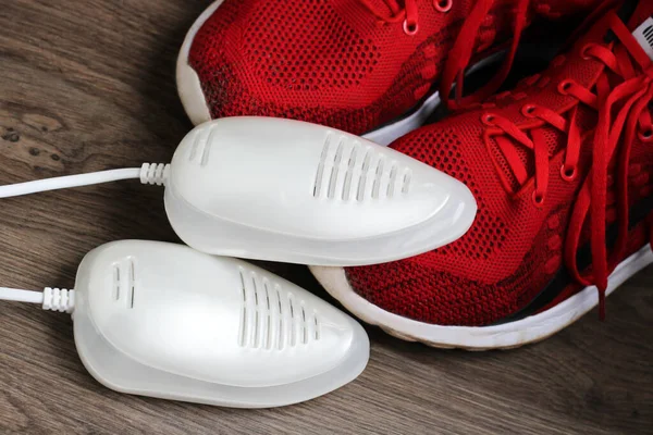 Elektrik ultraviyole ayakkabı kurutma makinesi ve kırmızı ayakkabılar çok yakın.