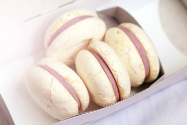 Karton kutuda beyaz kurabiyeler, tatlı. Güneş ışığı tonlu.