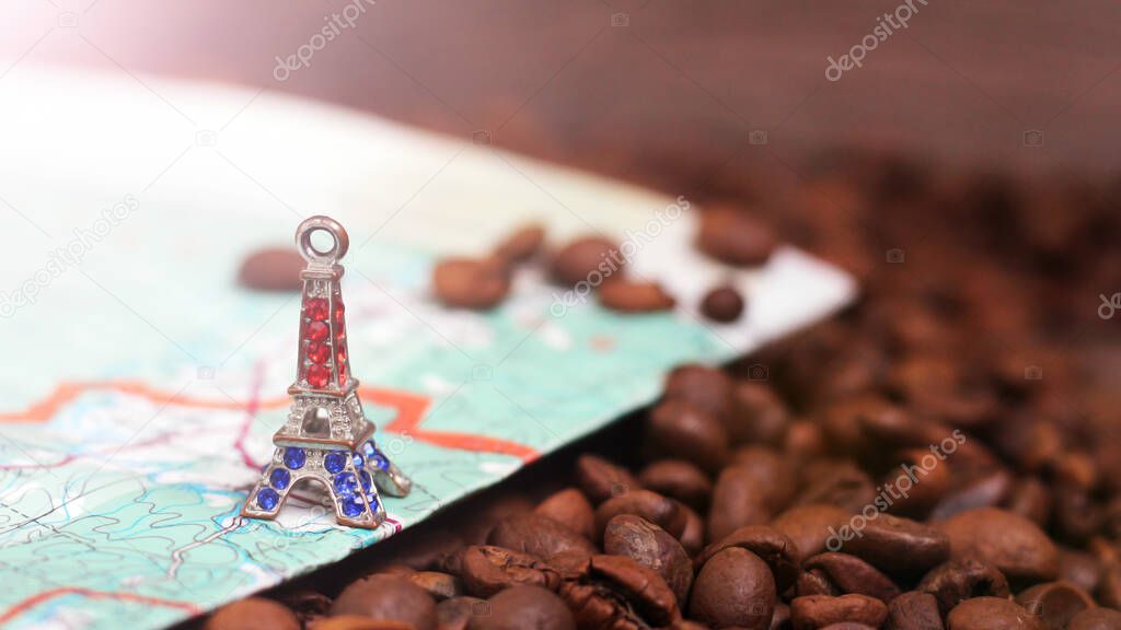 Small bronze of Eiffel tower figurine, compass and coffee beans so close