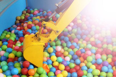 Çocuk parkında sarı yürüyen merdiven ve renkli plastik toplar, oyuncaklar.