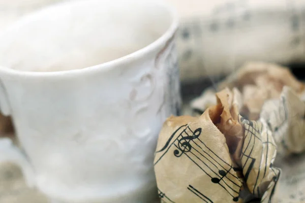 湯気のある白いコーヒーと音楽ノートがとても近い — ストック写真