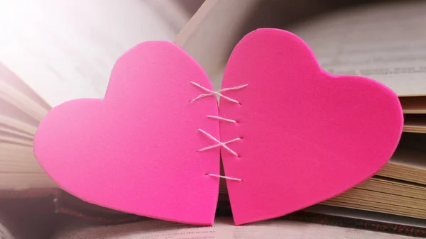 Two pink hearts and books, love and romance image