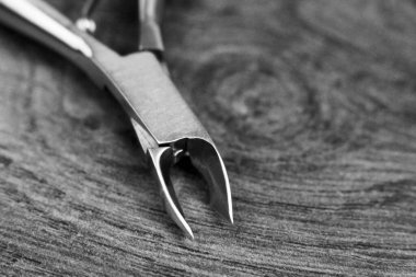 Ahşap arka planda paslanmaz çelik tırnak makası, çok yakın.