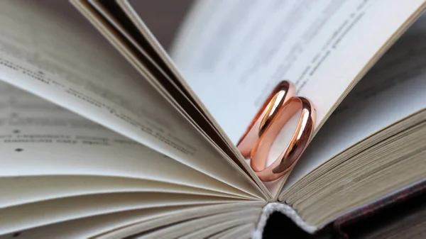 Pair of gold wedding bands on a bible, love