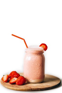 Çilek Muz smoothies. Çilek. Muz. Bir cam kabı. Beyaz arka plan. Lezzetli bir içecek. Pembe içecek. Diyet ürün. Kırmızı dut. Sarı meyve. Güneşli havalarda kokteyl. Yaz.