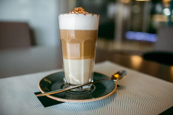 Café Latte Macchiato Café En Couches Dans Une Tasse à Café En Verre  Transparent Avec Des Grains De Café Sur La Table