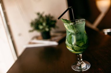 Mojito kokteyl alkolsüz kokteyl cam yiyecek. Ahşap bir masaya.